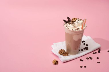 Yüksek açılı tek kullanımlık çikolatalı milkshake fındıklı ve peçeteli kahve taneli.