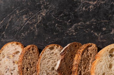 Taş siyah yüzeyde taze ekmek dilimlerinin üst görüntüsü
