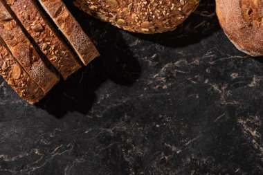 Taş siyah yüzeyde taze ekmek dilimlerinin üst görüntüsü