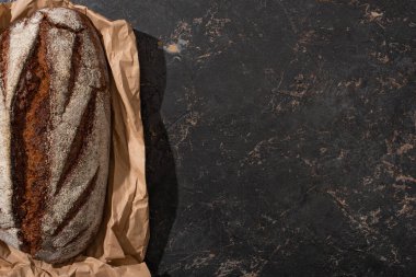 Taştan siyah yüzey üzerinde organik kahverengi ekmeğin üst görüntüsü