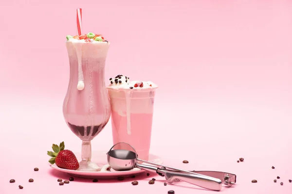 使い捨てカップとミルクセーキ イチゴとピンクのコーヒー粒とプレート上のスクープのガラス — ストック写真