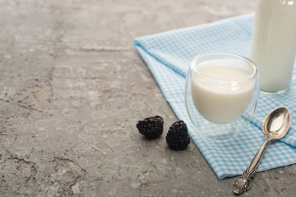 玻璃杯和一瓶自制酸奶 在灰色背景的黑莓附近的布上放茶匙 — 图库照片