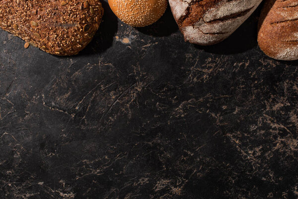 top view of fresh baked bread on stone black surface