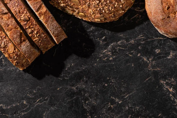 石黑表面新鲜面包片的顶部视图 — 图库照片