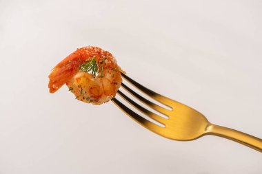 fried shrimps on parchment paper with sauce and lime near golden cutlery on white background clipart
