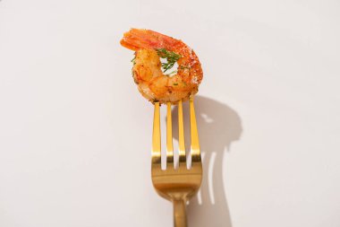 top view of fried shrimp on golden fork on white background clipart