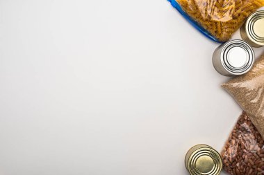 Beyaz arka planda fermuar poşetlerinde konserve ve inlemelerin üst görünümü, gıda bağışı konsepti