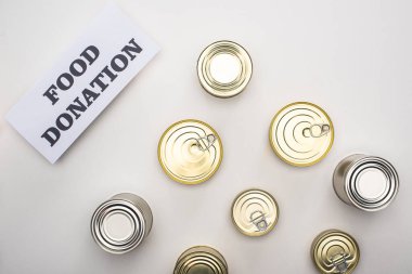 top view of cans with canned food on white background with food donation card clipart