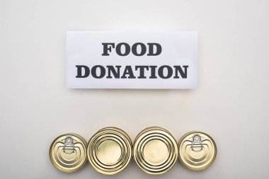 top view of cans with canned food on white background with food donation card clipart