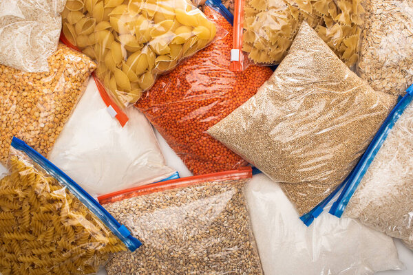 top view of groats and pasta in zipper bags, food donation concept