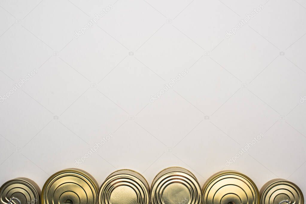 top view of golden cans with canned food on white background with copy space, food donation concept