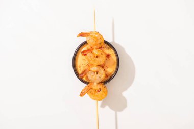 top view of delicious fried prawns on skewer with sauce on white background clipart
