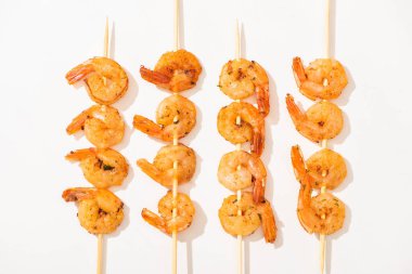top view of delicious fried prawns on skewers on white background clipart
