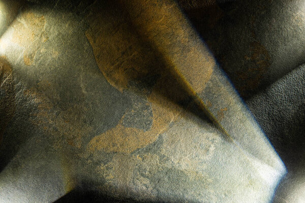 светлая призма с балками на темном фоне из камня
