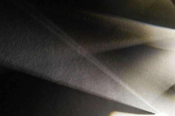 светлая призма с лучами на темном текстурированном фоне
