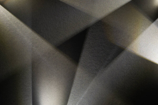 светлая призма с лучами на темном текстурированном фоне
