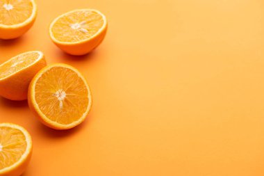 ripe delicious cut oranges on colorful background clipart