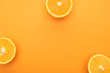 top view of juicy orange slices on colorful background clipart