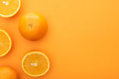top view of juicy whole oranges and slices on colorful background clipart