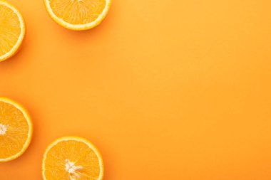 Renkli arkaplandaki olgun sulu portakal dilimlerinin fotokopi alanı ile üst görünümü