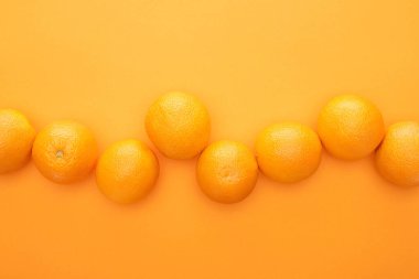 Renkli arkaplandaki olgun sulu portakalların üst görünümü