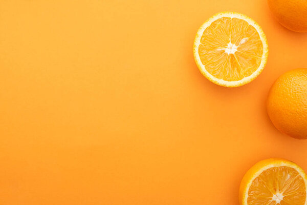 вид сверху на сочные апельсины и ломтики на красочном фоне
