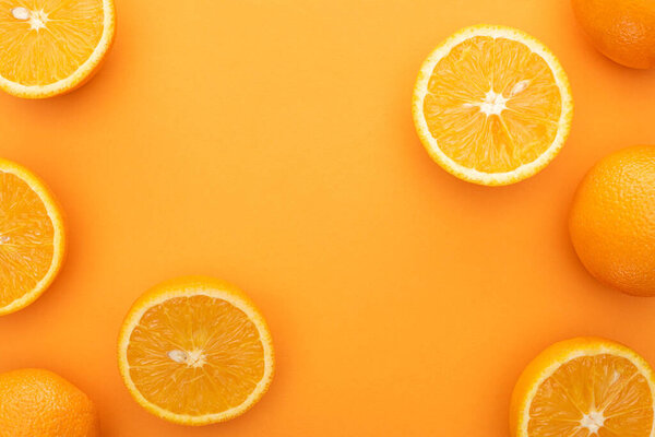 вид сверху на сочные апельсины и ломтики на красочном фоне
