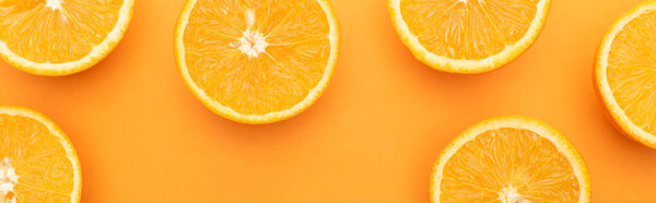 top view of ripe juicy orange slices on colorful background, panoramic crop