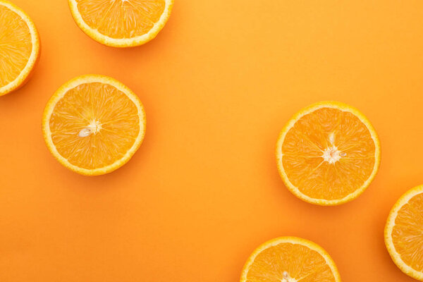 top view of ripe juicy orange slices on colorful background