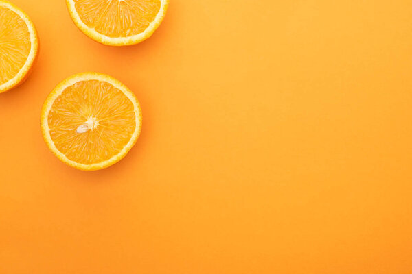 вид сверху на спелые сочные апельсиновые ломтики на красочном фоне с копировальным пространством

