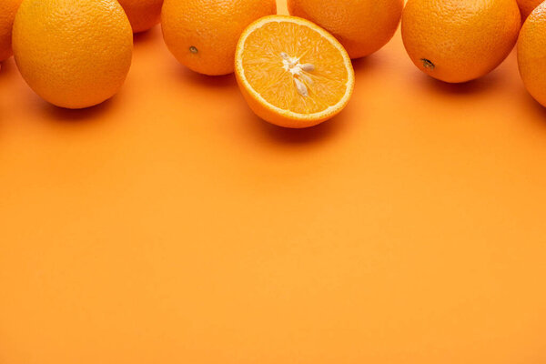 ripe juicy whole and cut oranges on colorful background