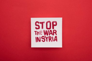 Suriye 'deki savaşı durduran beyaz afişin kırmızı arkaplanda yazılı olduğu en üst görünümü
