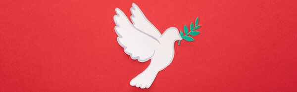 top view of white dove as symbol of peace on red background, panoramic crop