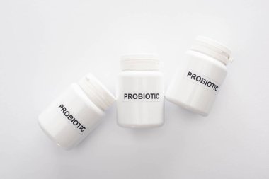 top view of containers with probiotic lettering on white background clipart