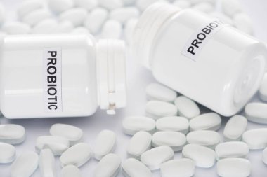 Probiyotik konteynırların seçici odak noktası ve beyaz arka planda haplar