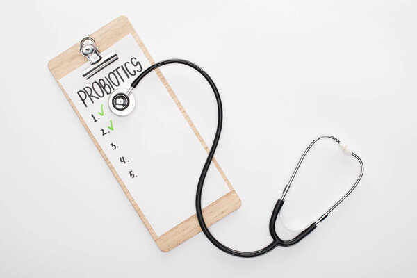 top view of clipboard with probiotics empty list and stethoscope on white background