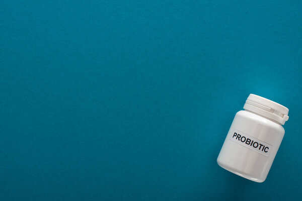 top view of white probiotic container on blue background