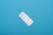 Ansicht von Pillen in Blisterverpackung auf blauem Hintergrund
