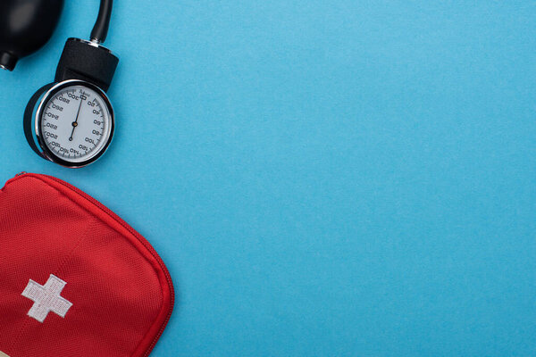 вид сверху на аптечку и сфигмоманометр на синем фоне
