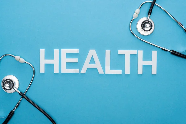 Bovenaanzicht Van Gezondheidsletters Stethoscopen Blauwe Achtergrond — Stockfoto