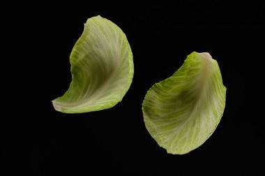 top view of wet green cabbage leaves isolated on black clipart