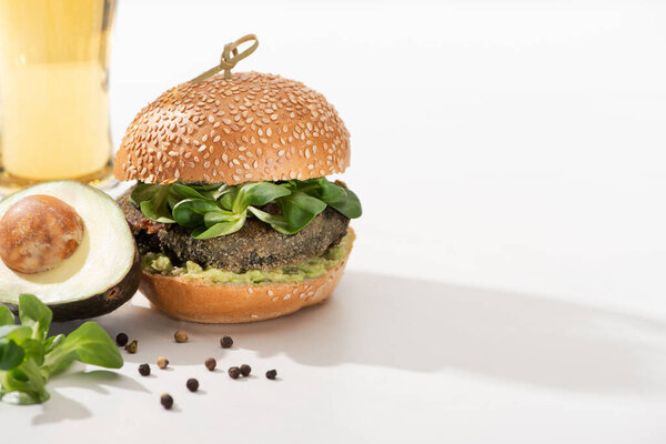 delicious green vegan burger with microgreens, avocado, black pepper on white background