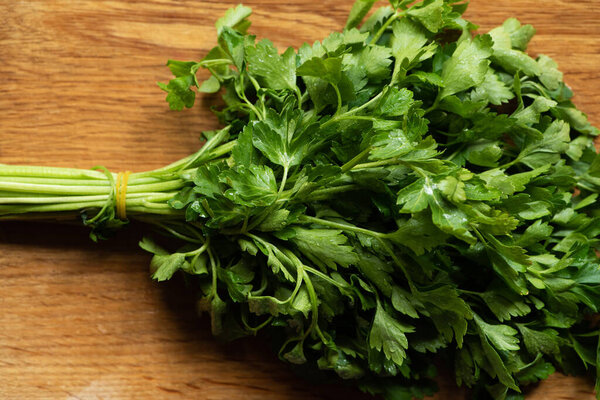 top view of fresh green parsley on wooden surface