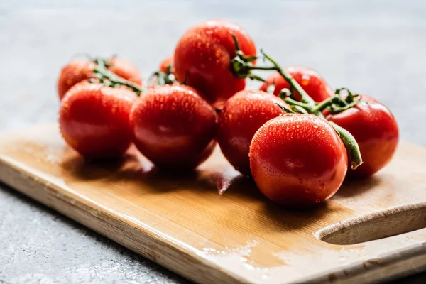Φρέσκες Ώριμες Κόκκινες Ντομάτες Κλαδί Σταγόνες Νερού Ξύλινη Σανίδα Γκρι — Φωτογραφία Αρχείου
