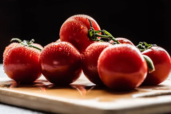 Färska Mogna Röda Tomater Gren Med Vattendroppar Träskiva Isolerade Svart — Stockfoto