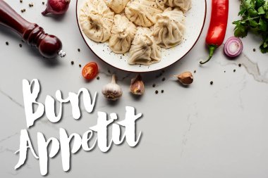 Sebze ve baharatların yakınındaki lezzetli khinkali 'nin üst görüntüsü mermer masada, afiyet olsun.