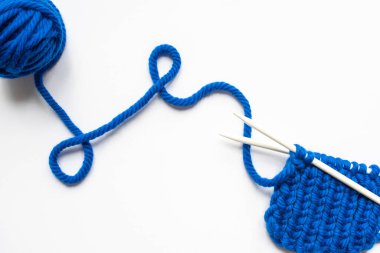 top view of blue wool yarn and knitting needles on white background clipart