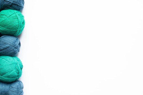 верхний вид синей и зеленой шерсти пряжи на белом фоне с копировальным пространством
