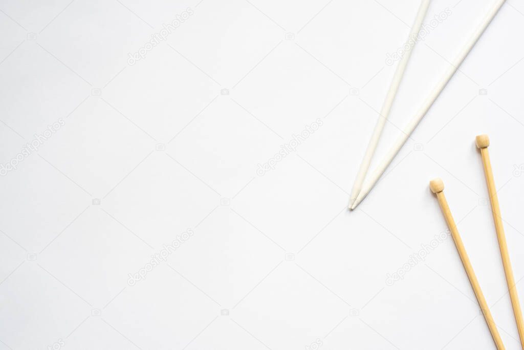 top view of knitting needles on white background