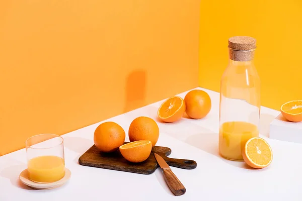 Świeży Sok Pomarańczowy Szklance Butelce Pobliżu Dojrzałych Pomarańczy Desce Krojenia — Zdjęcie stockowe